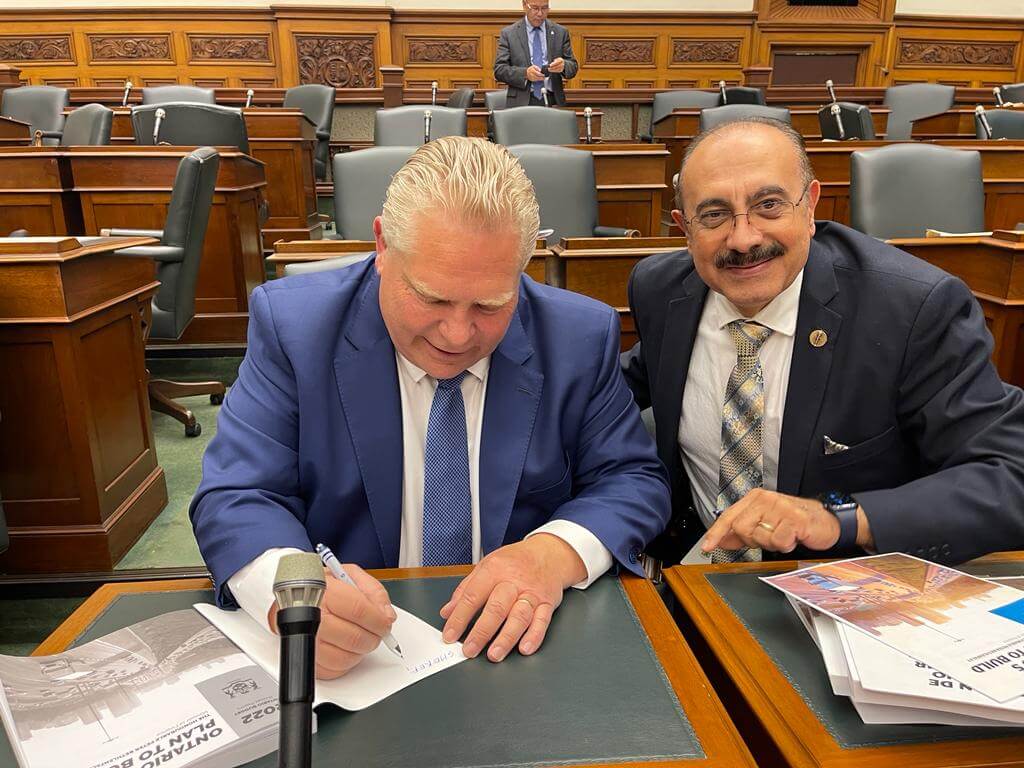 Premier Ford and Sheref Sabawy sign a copy of Ontario's 2022 Budget.