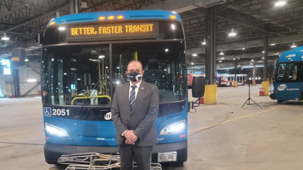 MPP Sabawy stands in front of a blue express MiWay bus that reads, "Better, Faster, Transit"